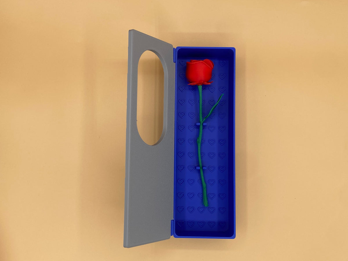 Open blue-and-gray gift box displaying a single red rose with a green stem