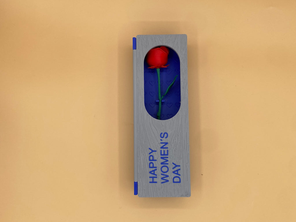 Closed blue-and-gray Women's Day gift box with a red rose visible through the window