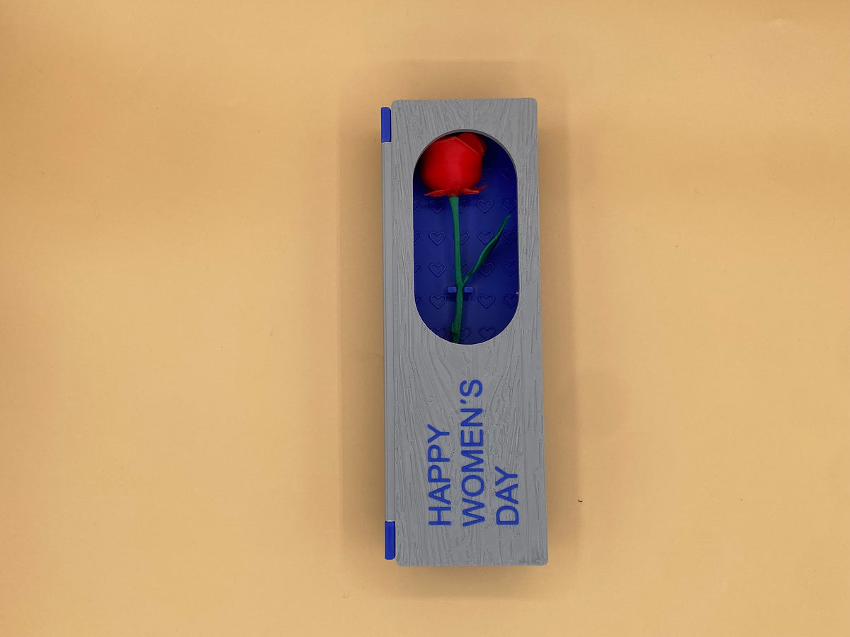 Closed blue-and-gray Women's Day gift box with a red rose visible through the window
